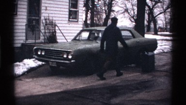 1971: a man heating the car before driving on a typical frozen winter day