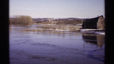 1971: house on riverbank in winter with snowy background WISCONSIN