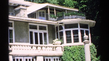 1970: a bungalow with two floors and small plants are located in front of the