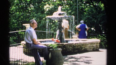 1970: small group of people gathered around a fountain, enjoying a park and