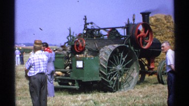 1971: the tractor powered with coal park on front straw, and man look around.