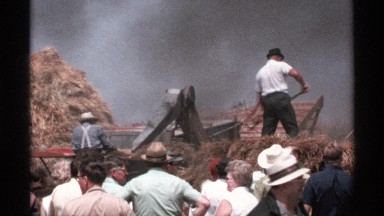 1971: people are working at outdoor they are firing the hay and using a vehicle