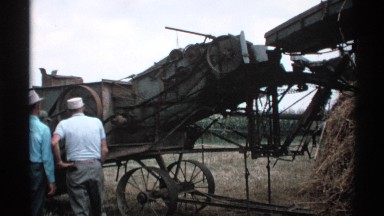 1971: two men in white hats operating a large piece of farm equipment MINNESOTA