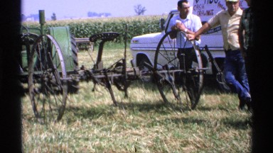 1971: a group of farmers examining their equipment while having a conversation.