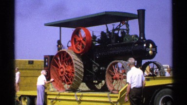 1971: a large size transport vehicle and people are doing repair on the vehicle