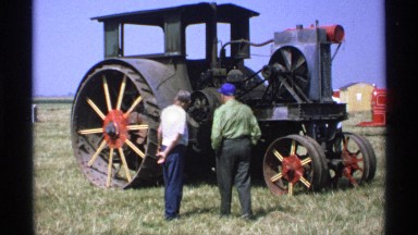 1971: two men are talking in front of a vehicle that used for farmers and it