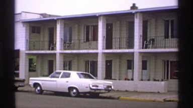 1971: White Building Has Two Terraced Stories with Windowed Units and Doors ISLE