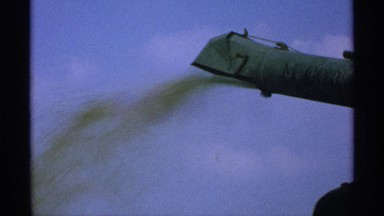 1971: a farm machine spewing grain seemingly into the wind MINNESOTA