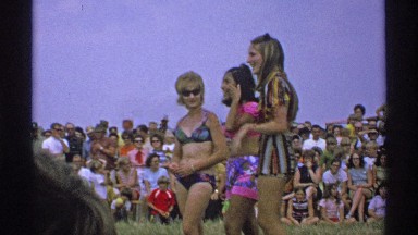1971: Three Women Standing in Front of a Crowd in Minnesota