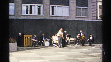 1972: Group of people gathered around a stage performance enjoying music with