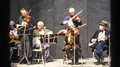 1972: musicians playing the violin while the man with the banjo waits his turn
