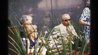 1972: People Watching Another Person Playing an Instrument Outside in the Wind