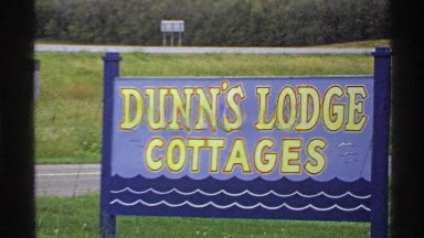 1971: sign for dunn's lodge cottages and beautiful park with water wheel ROLLAG