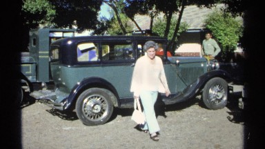 1975: a lady with a bag walking around nicely and searching something at the