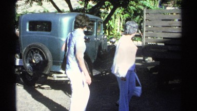 1975: two ladies are walking in front of the vehicles and searching something at