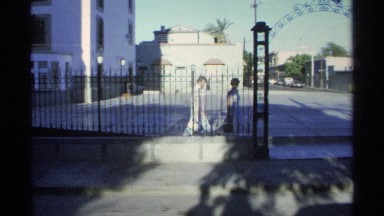 1975: women walking through gate and down the street GUAYMAS MEXICO