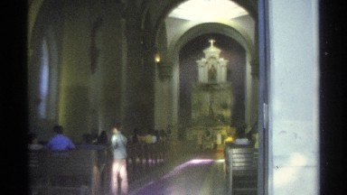 1975: people sit down in the pews of a cathedral as they watch someone sit in