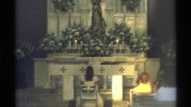 1975: two people sitting by the altar in a church waiting for the priest to come