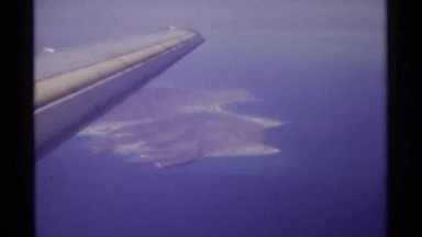 1974: airplane flying high above an island in the ocean LA PAZ MEXICO