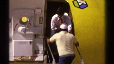 1974: three men boarding a yellow airplane, women picking up her luggage LA PAZ