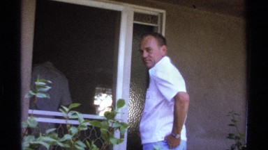 1974: a man talk with some other and opened his house and laugh with the person