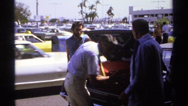 1974: a man takes his luggage and the rest of his belongings from his car and