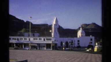 1975: buildings are located at the city and it look like a prayer hall and cars