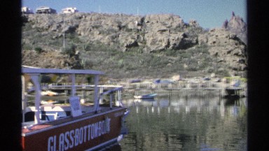 1975: a panoramic shot of a lake surrounded by mountains and filled with boats