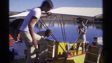 1975: some people are standing at boat and arranging things to place at the boat