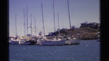 1975: a place of water and boats are landing there only one boat moving at the