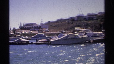 1975: more boats and ships are located at the water that looks like harbor place