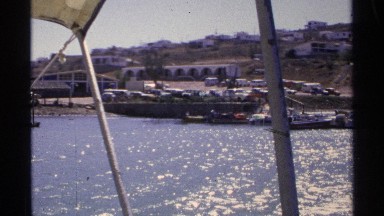 1975: a harbor place and more boats are parking at water and a boat moving on