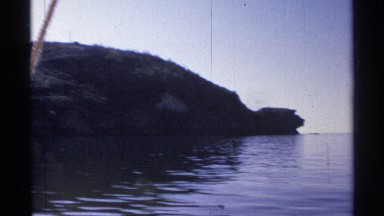 1975: boat approaches narrow passage formed by two extending landforms GUAYMAS