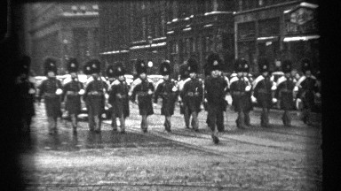 1937: the army people are walking rally at the road and more buildings also at