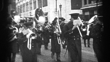 1937: men in uniform marched down the street, playing instruments in a band