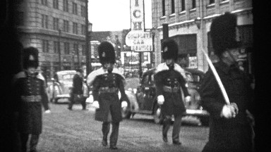 1937: parade in downtown with buildings and soldiers in british uniform and fur