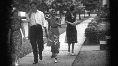 1938: a cheerful family taking a stroll in their neighborhood while someone