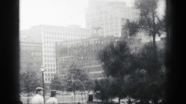 1938: the view of a city with skyscrapers, large buildings, pedestrians, moving