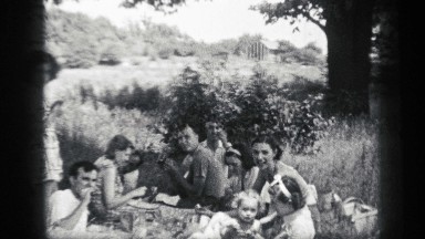 1938: party of friends and family enjoying a lunch under the shade of a tree.