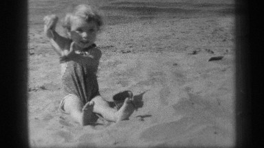 1938: a little girl is playing in the sand while spending a nice summer day on