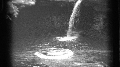 1938: a falls and the water flooding at a dam and it may be a forest and steps
