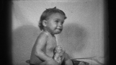 1938: a little boy at home and taking his toy at the bathtub and doing brush to