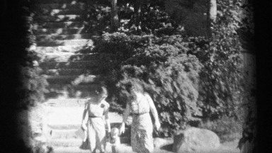 1938: two women walk hand in hand with a toddler down rough hewn steps in a