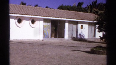 1974: people walking past a white house. CABO SAN LUCAS MEXICO