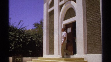 1974: two men are coming from their house and some trees are surrounding there