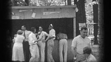 1937: group of adults at a concession stand posing and talking to the camera