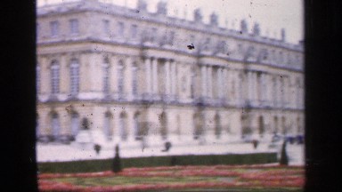 1957: Visitors Strolling Through Landscaped Garden in Front of Wide Palace
