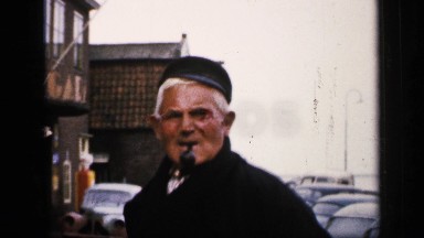 1957: A Man Standing With a Pipe in His Mouth Watching a Dutch Street Scene