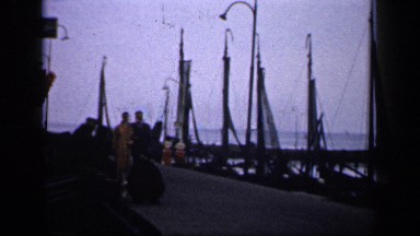 1957: Couple Walking Near the Beach, Enjoying the View of Boats, the Sea and the