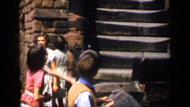 1957: still shot of a little girl and little boy in front of stone steps in the